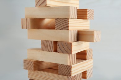 Jenga tower made of wooden blocks on white background, closeup