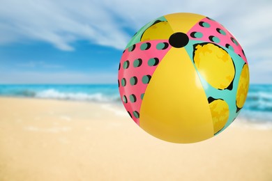 Colorful inflatable beach ball and seascape on background
