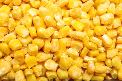 Photo of Pile of frozen corn kernels as background, closeup