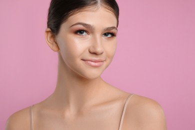 Pretty girl on pink background. Beautiful face with perfect smooth skin