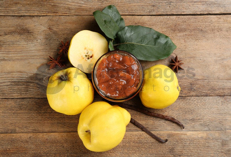 Photo of Delicious quince jam and fruits on wooden table, flat lay