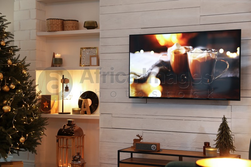 Photo of Plasma TV on white wooden wall in living room beautifully decorated for Christmas
