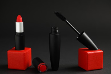 Beautiful lipstick and mascara on black background