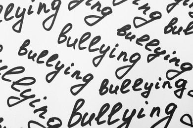 Top view of words Bullying written on white background, closeup