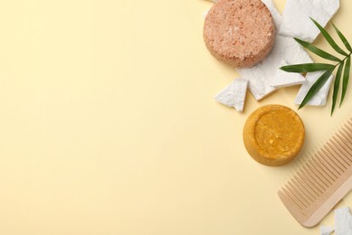 Flat lay composition of solid shampoo bars, leaf and comb on beige background. Space for text