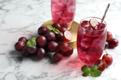 Delicious grape soda water with mint and berries on white marble table. Refreshing drink