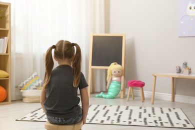 Lonely little girl at home, back view. Autism concept
