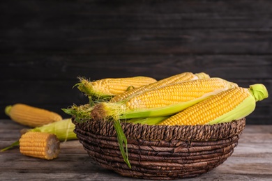 Basket with tasty sweet corn cobs on table