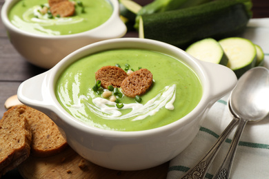 Tasty homemade zucchini cream soup served on table