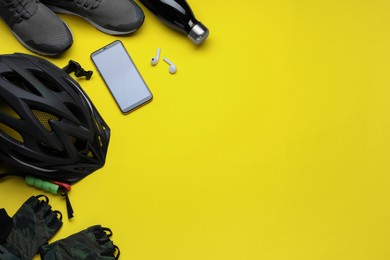 Flat lay composition with different cycling accessories on yellow background, space for text
