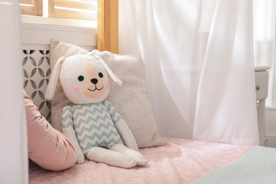 Toy dog on bed in child's room. Space for text