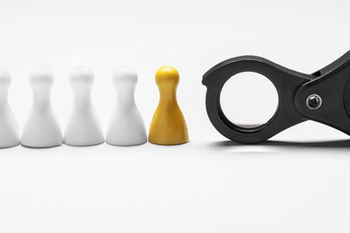 Photo of Yellow pawn among others near magnifying glass on white background. Recruiter searching employee