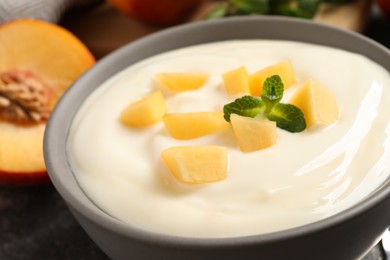 Delicious yogurt with fresh peach and mint in bowl, closeup