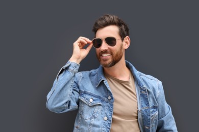 Portrait of handsome bearded man with sunglasses on grey background. Space for text