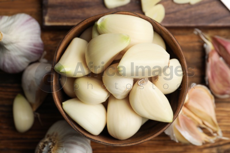 Fresh organic garlic on wooden table, flat lay