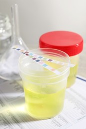 Containers with urine samples for analysis and glassware on test forms in laboratory