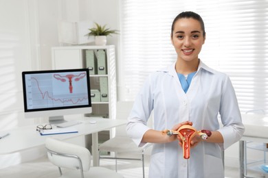 Gynecologist demonstrating model of female reproductive system in clinic