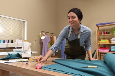 Photo of Dressmaker taking pin from cushion in workshop