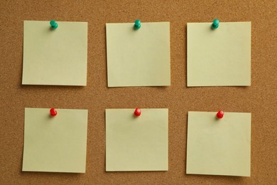 Beige paper notes pinned to cork board