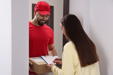Woman signing for delivered parcel at home