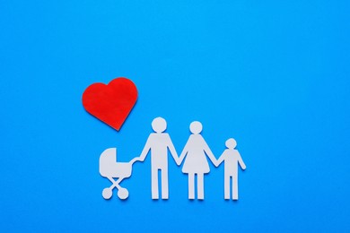 Paper family cutout and red heart on light blue background, flat lay. Insurance concept