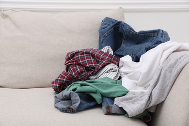 Pile of dirty clothes on sofa in living room