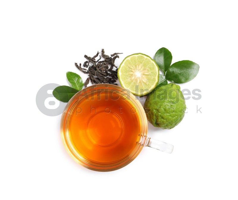 Glass cup of tasty bergamot tea, dry leaves and fresh fruits on white background, top view