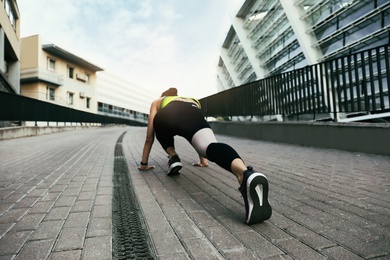 Young woman stretching after running on street