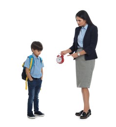Teacher with alarm clock scolding pupil for being late against white background