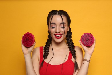 Photo of Young woman with fresh pitahaya on yellow background. Exotic fruit