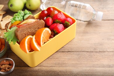 Photo of Lunch box with healthy food on wooden table. Space for text
