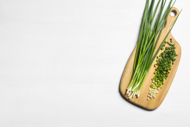 Fresh green onion on white wooden table, top view. Space for text
