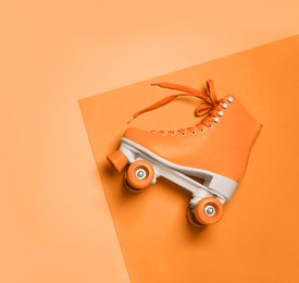 Stylish quad roller skate on orange background, top view