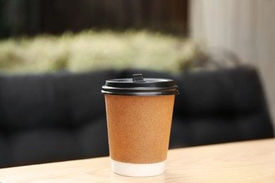 Photo of Paper cup on table in outdoor cafe. Coffee to go