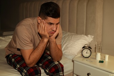 Man suffering from insomnia on bed at night