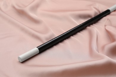 Beautiful black magic wand on pink fabric