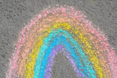 Rainbow drawn with colorful chalks on asphalt outdoors, closeup