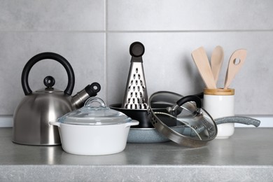 Set of cooking utensils and cookware on grey countertop