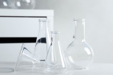 Set of laboratory glassware on white table indoors