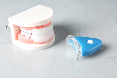 Educational model of oral cavity with teeth and whitening device on table