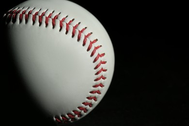 Photo of Baseball ball on black background, closeup with space for text. Sports game