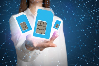 Woman demonstrating SIM cards of different sizes on color background, closeup 