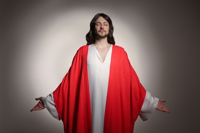 Jesus Christ with outstretched arms on beige background