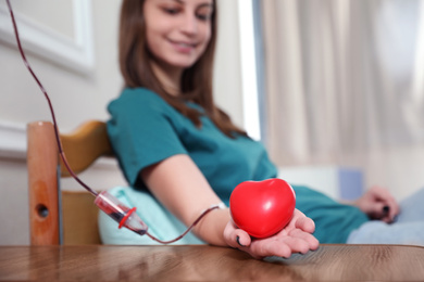 Photo of Teenager donating blood in hospital, focus on hand
