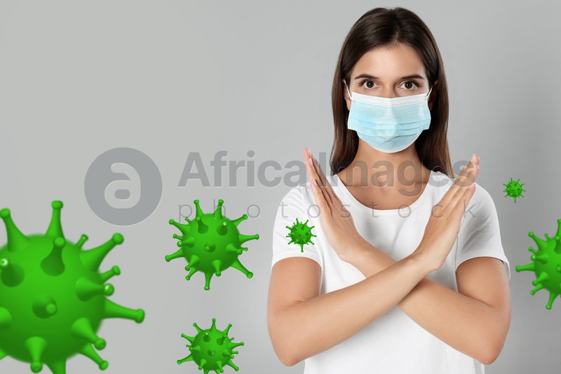 Stop Covid-19 outbreak. Woman wearing medical mask surrounded by virus on light background