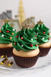 Photo of Christmas tree shaped cupcakes on white table
