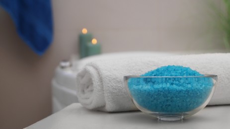 Bowl with bath salt and fluffy towel on table in bathroom. Space for text