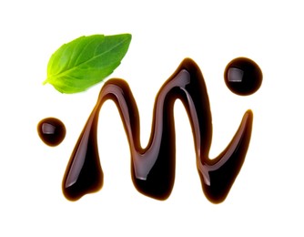 Photo of Balsamic glaze and basil leaf on white background, top view