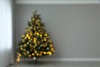 Blurred view of beautifully decorated Christmas tree indoors, space for text