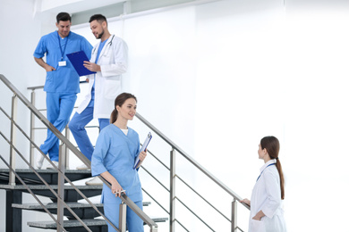 Team of professional doctors on staircase in clinic